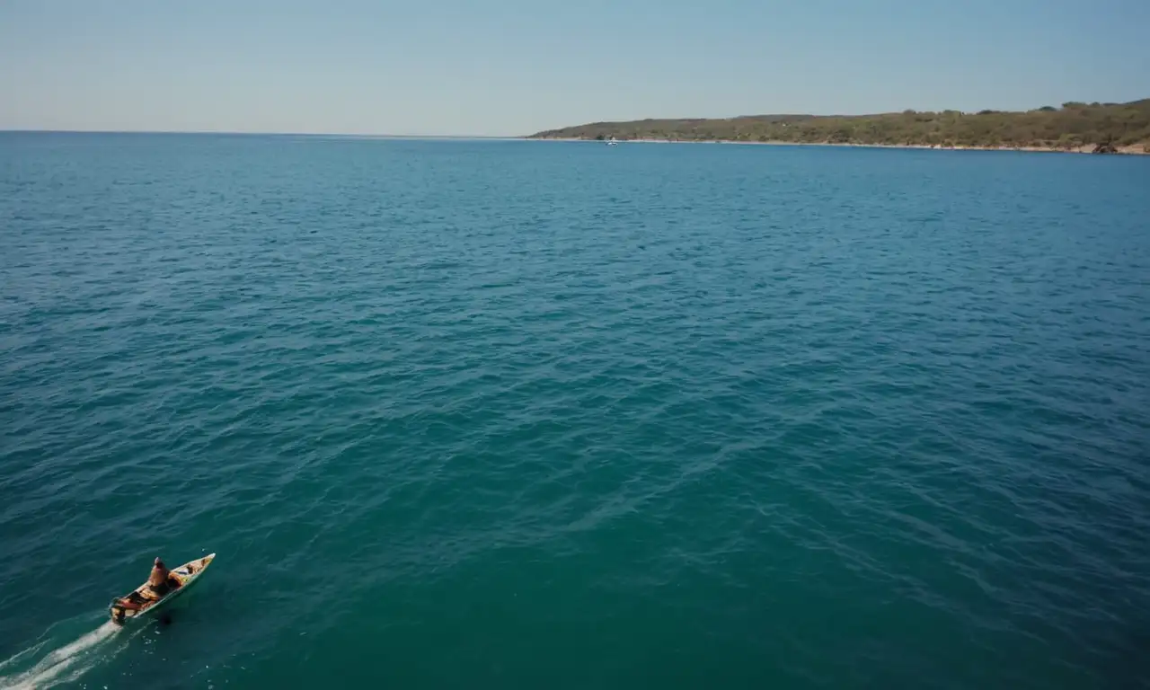 Gente navegando aguas tranquilas con ondas o ondas en el fondo.