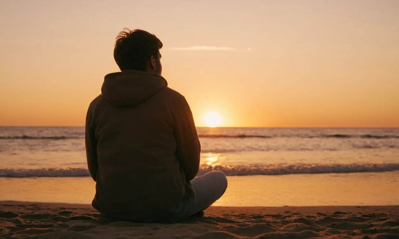 Una persona sentada en una playa al atardecer, reflexionando sobre sus sentimientos.